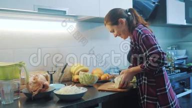厨房里的女人准备一顿饭的概念。 生活方式中的女孩厨房用刀<strong>切白菜</strong>。 做素食者
